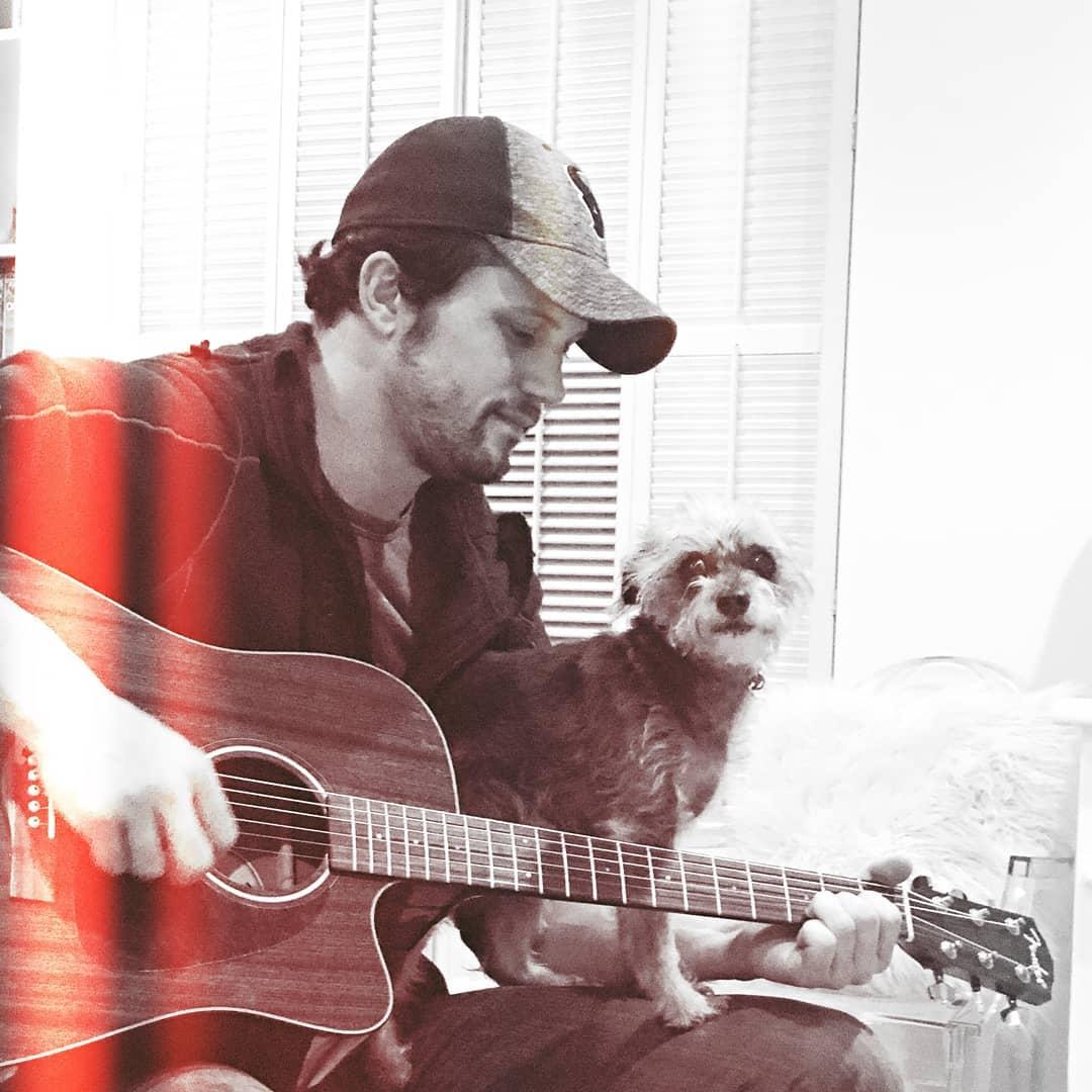 Nathan Parsons with his dog making music