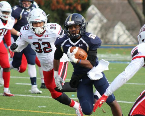 football player carrying brown football